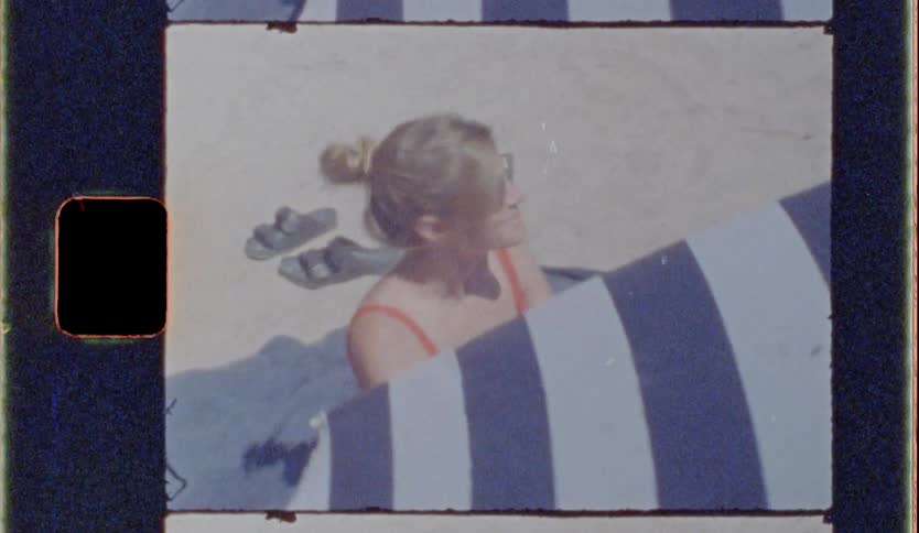 Blonde woman wearing sunglasses sitting next to a tent