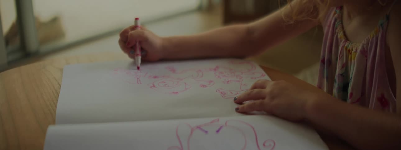 Girl drawing in her sketchbook at a table