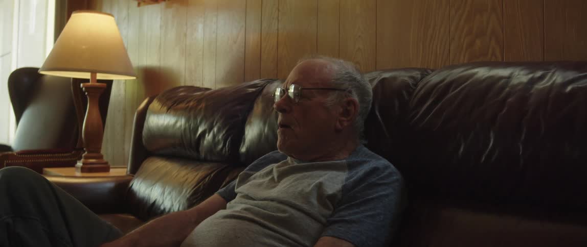 Nervous elderly man sitting down on a couch