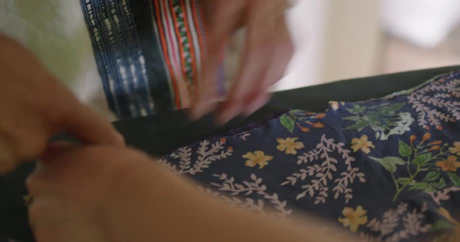 Two people examine some fabric