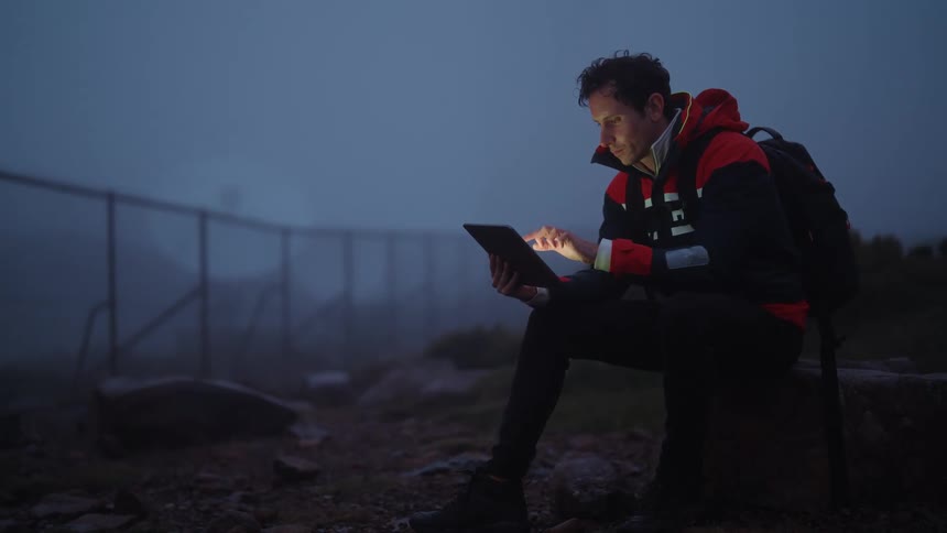 A man is using his tablet outside