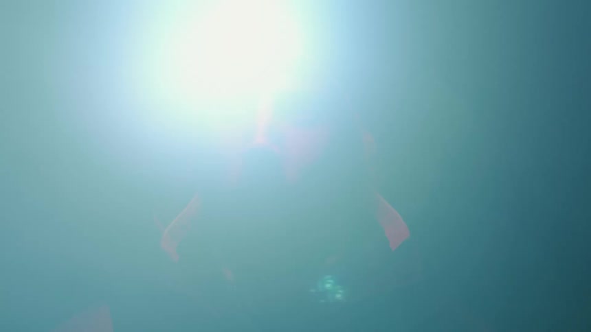 A man wearing a headlamp looks side to side in the darkness