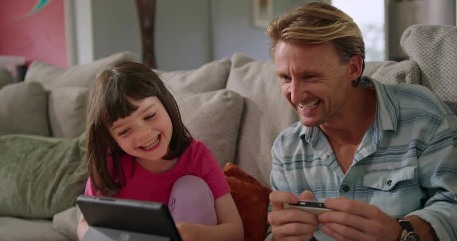 A father and daughter play video games together