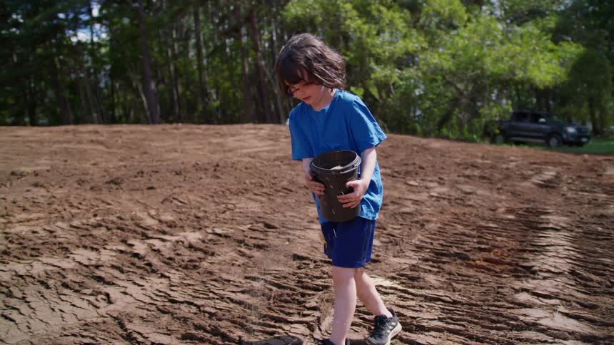 A child is spreading seeds on the field