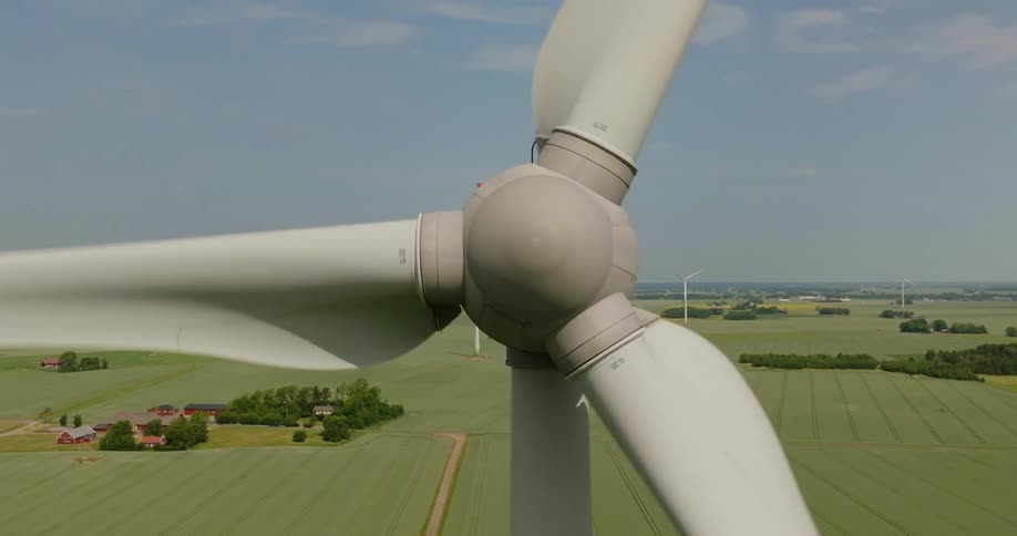 The tall windmill is spinning