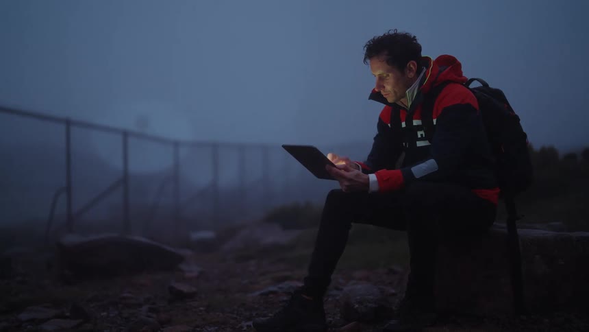 A man is using his tablet outside