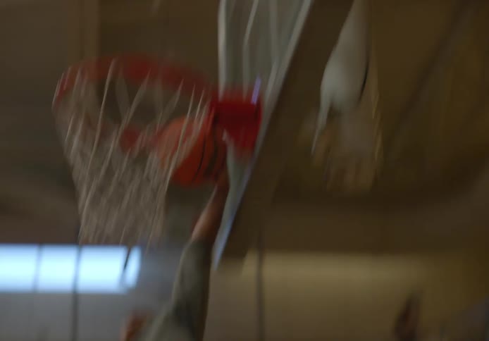 Young man scoring a point in a basketball game with his friends on a university basketball court