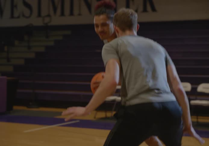 Two friends having fun playing basketball on a university basketball court