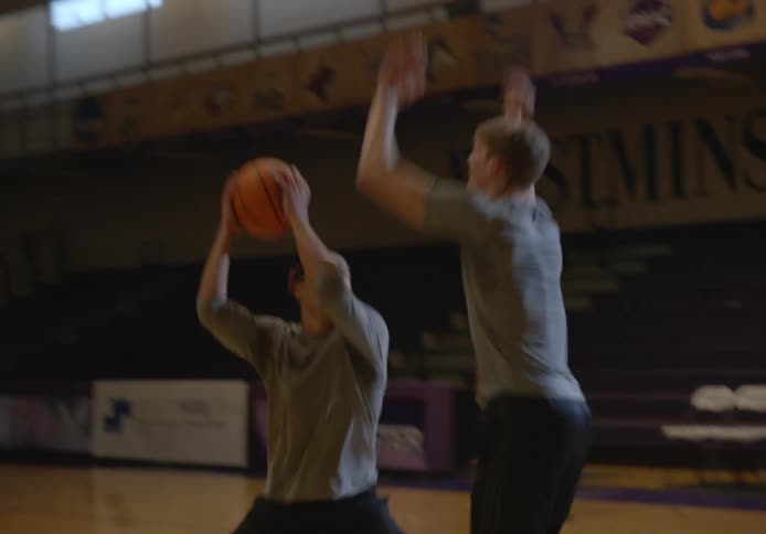 Friends playing basketball on a university basketball court