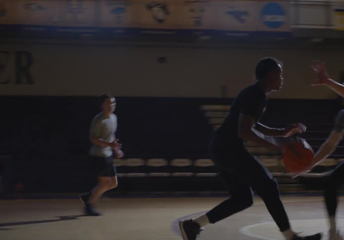 Three people are playing basketball