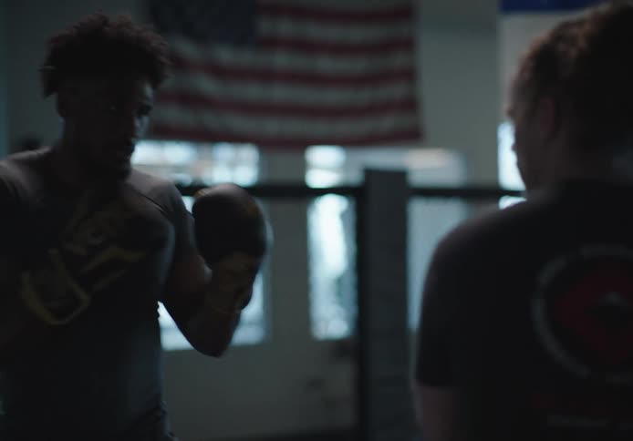Two men are sparring in the gym