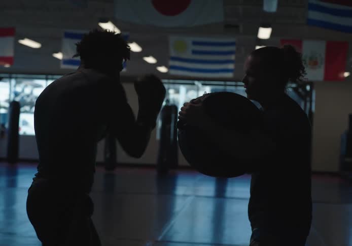 Two black men box training in a gym