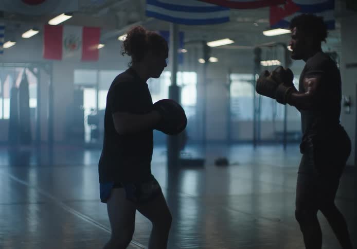 Focused man and woman practicing boxing in an empty gymnasium