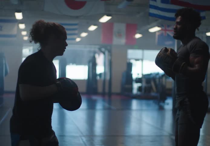 Man and woman training boxing in a gym practicing punches and defenses