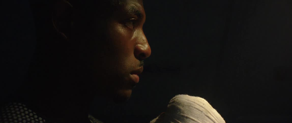 A man with wrapped hands is in the dark