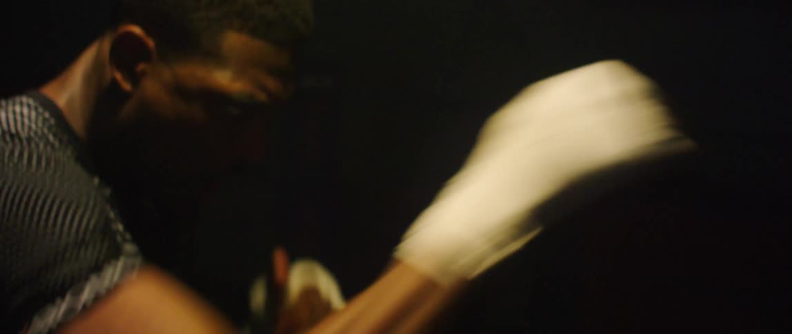 Man with fingerless gloves practicing boxing punches in the air