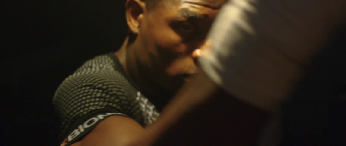 Man wearing fingerless gloves practicing boxing throwing punches in the air