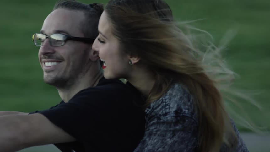 A man and woman ride on a motorcycle