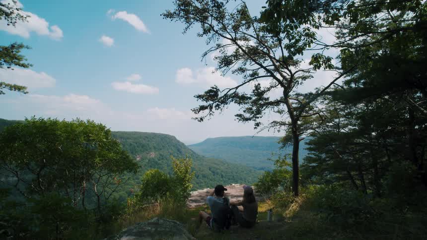 Two people are camping in the shade