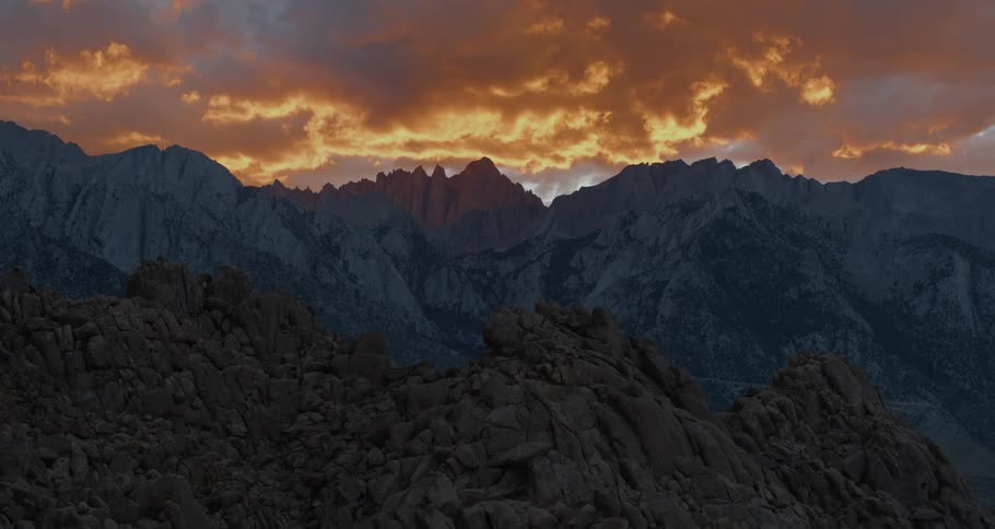 A jagged mountain range under a cloudy evening sky