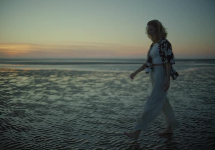 A woman is walking near the water
