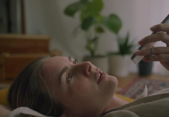 Woman lying on the floor indoors talking on a smart phone