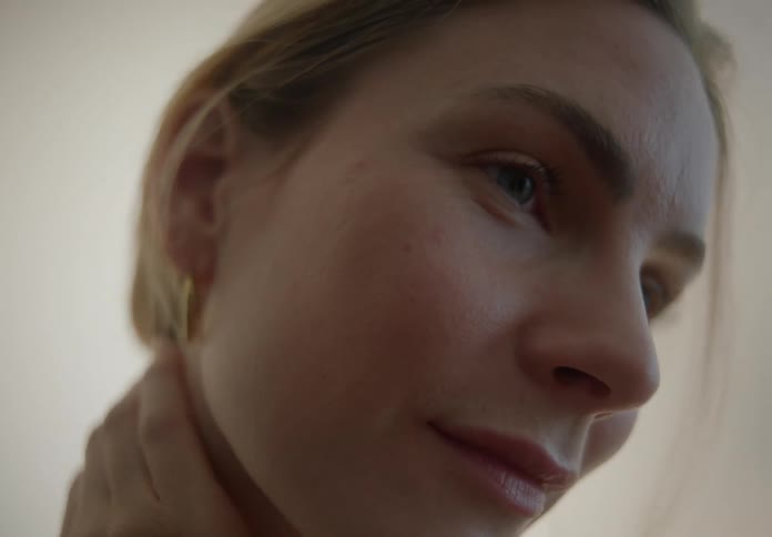 Woman gently running her hand over her face