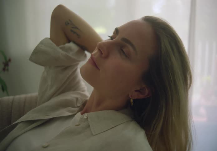 A woman brushes her hair back