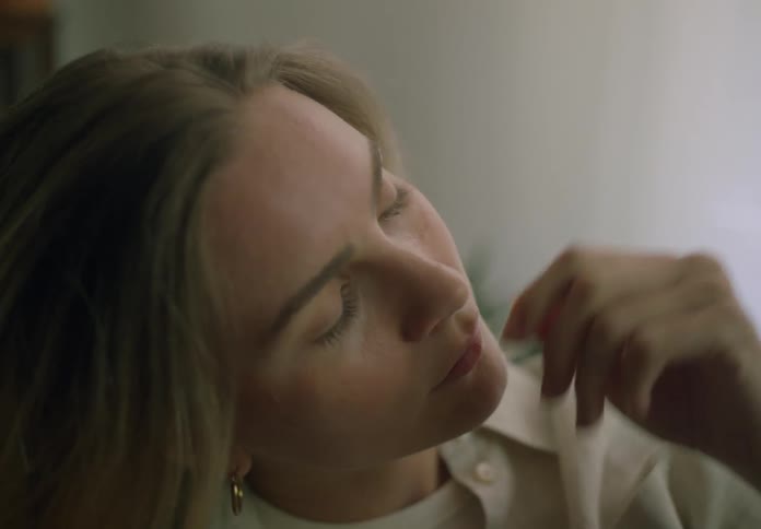 A woman brushes her hair back