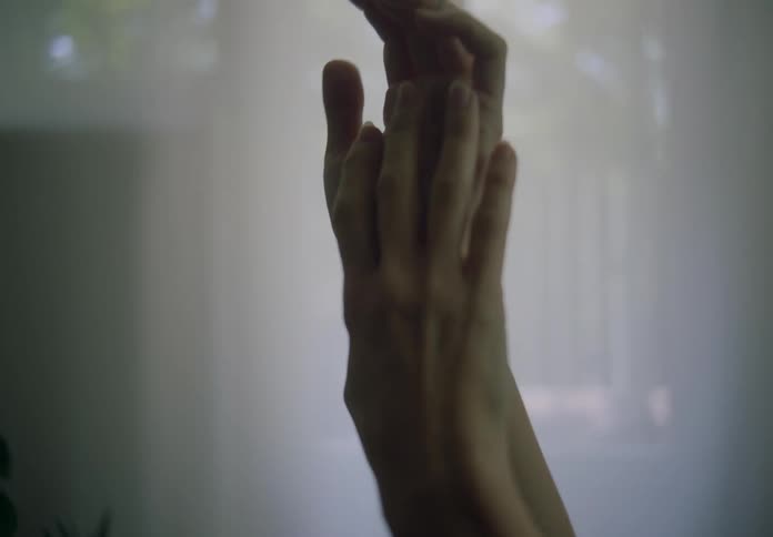 Woman running her hand over her tattooed arm and other hand