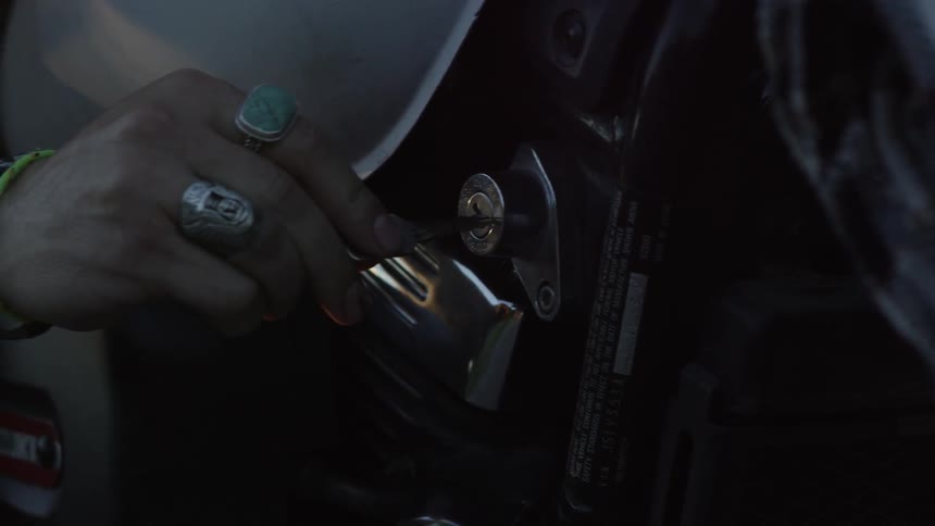 A hand puts a key into an ignition