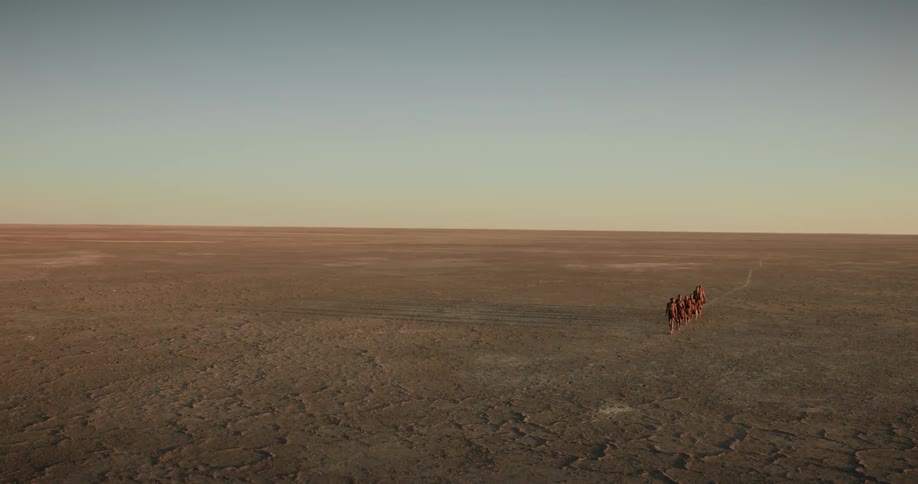 A group of tribesmen hikes in the desert