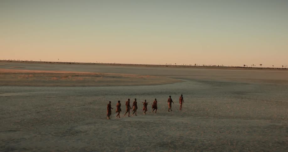 Row of tribesmen crossing the desert on foot