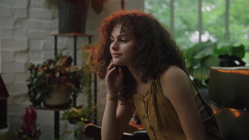 A young woman smiles after sitting and contemplating things for a few moments