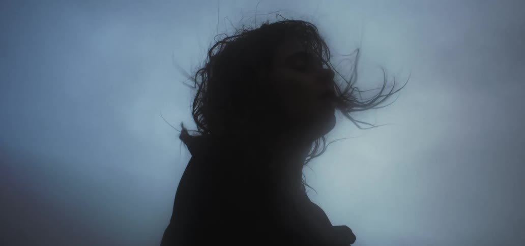 A woman is outside on a windy day