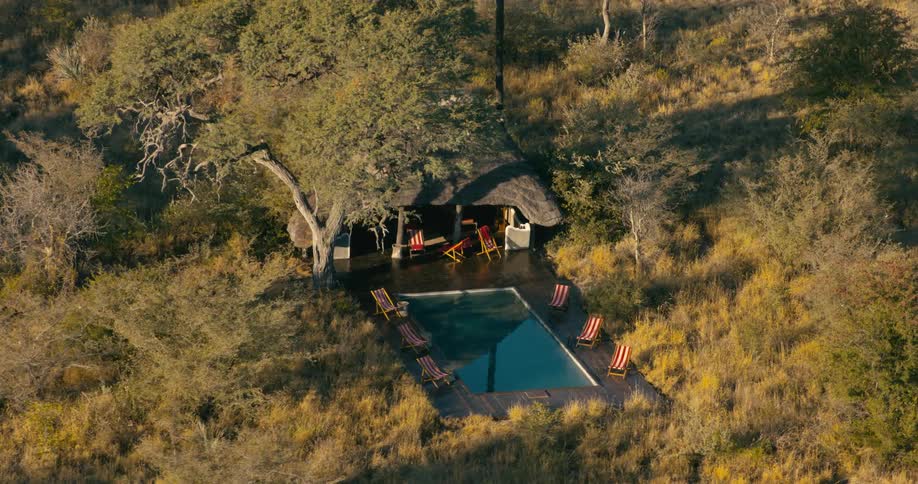 Small house with pools sits surrounded by wilderness