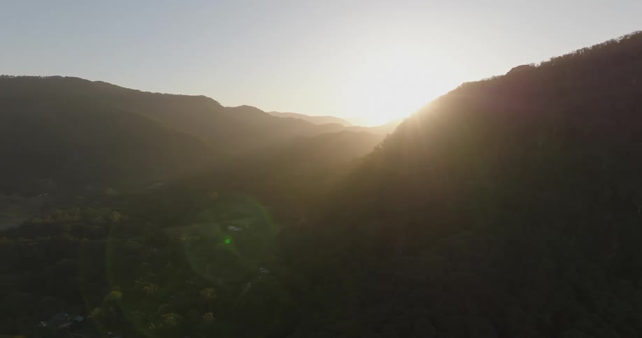 Aerial shot of a valley between two mountain ranges during dusk or dawn