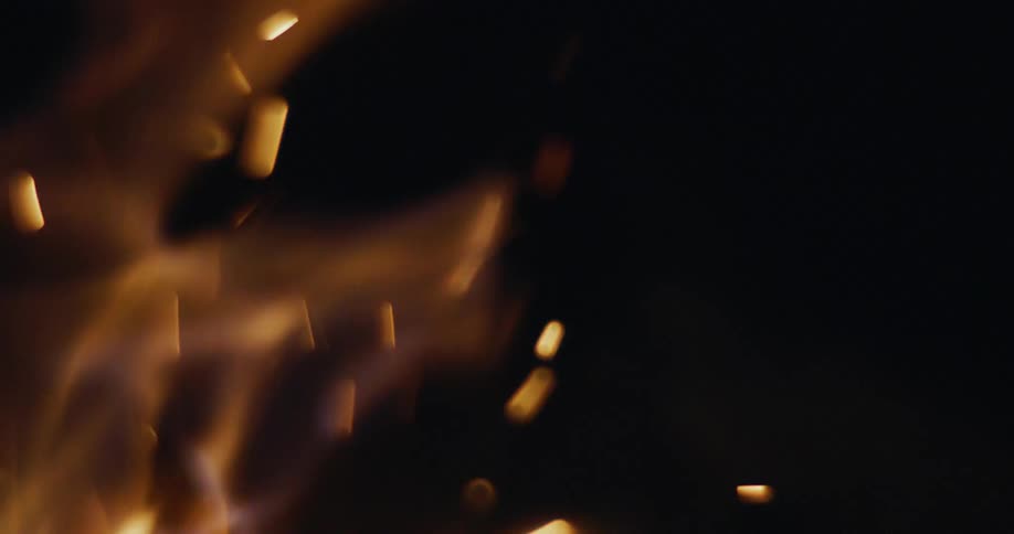 A small fire releases small sparks into the air as it burns