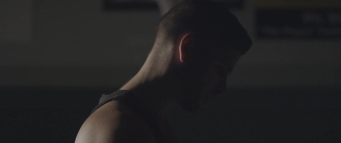 A man looks down in a dark room