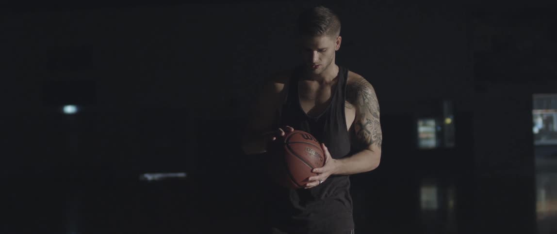 A man rolls a basketball around in his hands