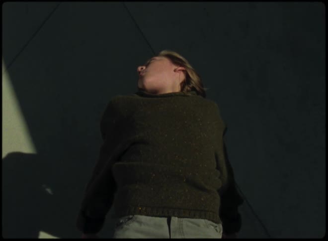 A  boy laying on his back floats across pavement