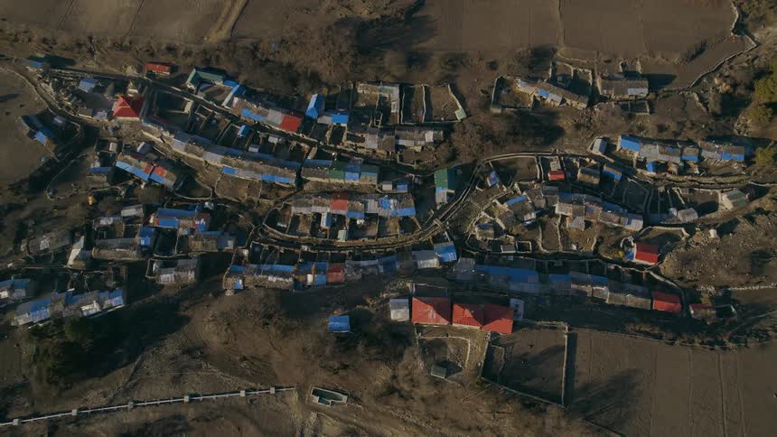 Aerial view of buildings with red and blue roofs in town
