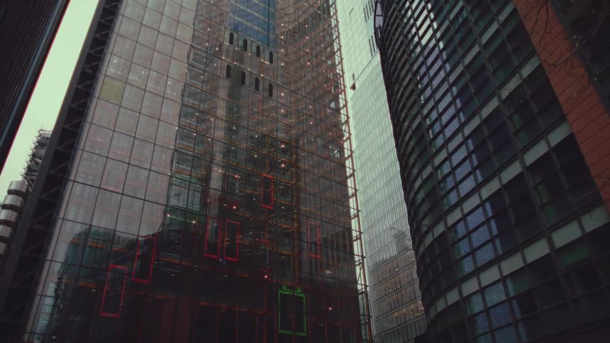 Buildings reflect off a mirrored skyscraper downtown