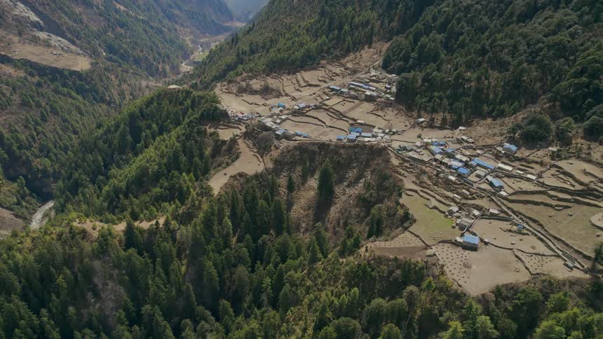 A small village containing several buildings sits part way up a mountain