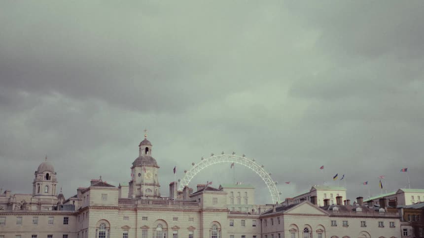 A large architectural building with an arch on top with flags on it