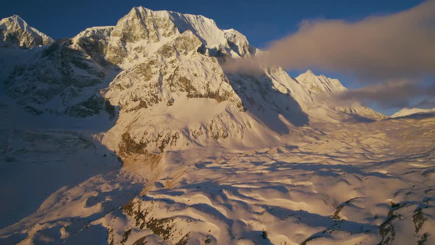 Aerial view of snowy mountain ridge and clouds