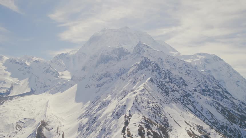 A blanket of snow covers a steep mountain range