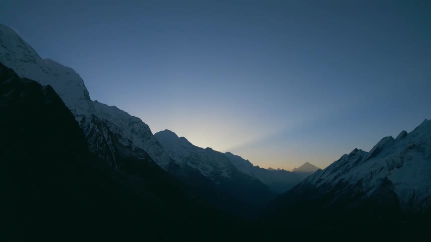 A mountain range with snow at sunrise