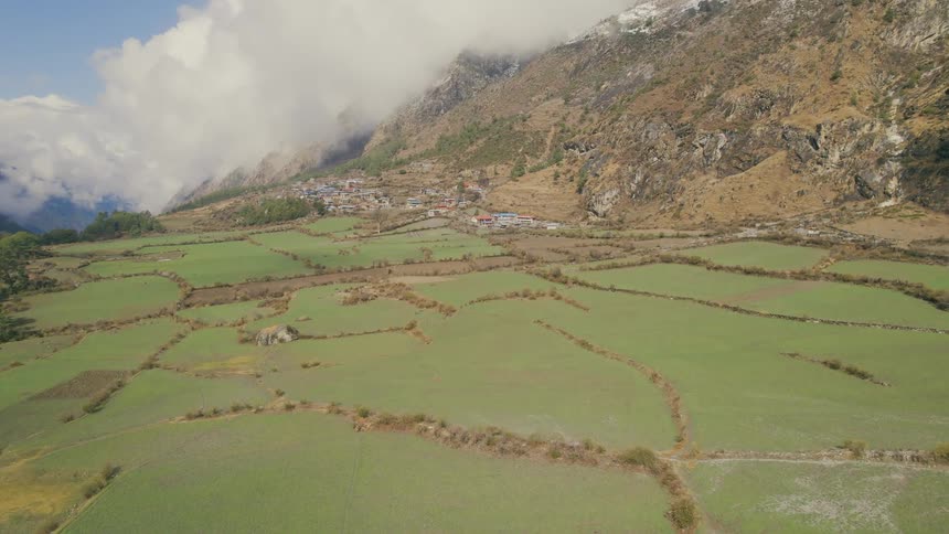 A field lined with rock paths sits below a canyon