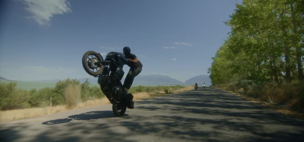 A man is riding his motorcycle as others follow